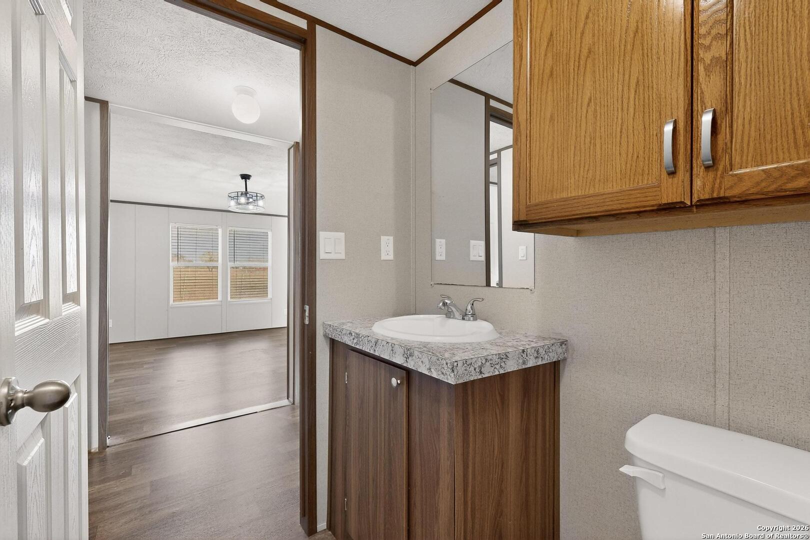 19124 La Gloria Road Elmendorf, TX 78112 - Photo 26 of 45 a bathroom with a sink a toilet and shower