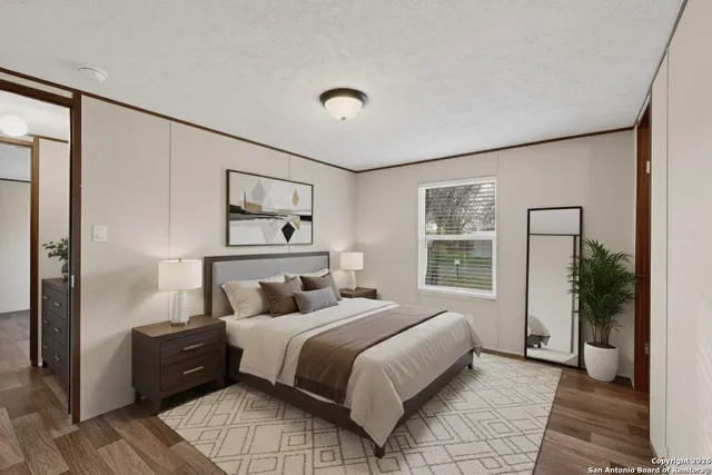 a bedroom with a large bed and a chandelier