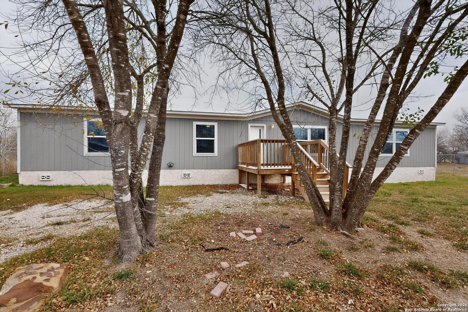 19124 La Gloria Road Elmendorf, TX 78112 - Photo 40 of 45 a backyard of a house with table and chairs