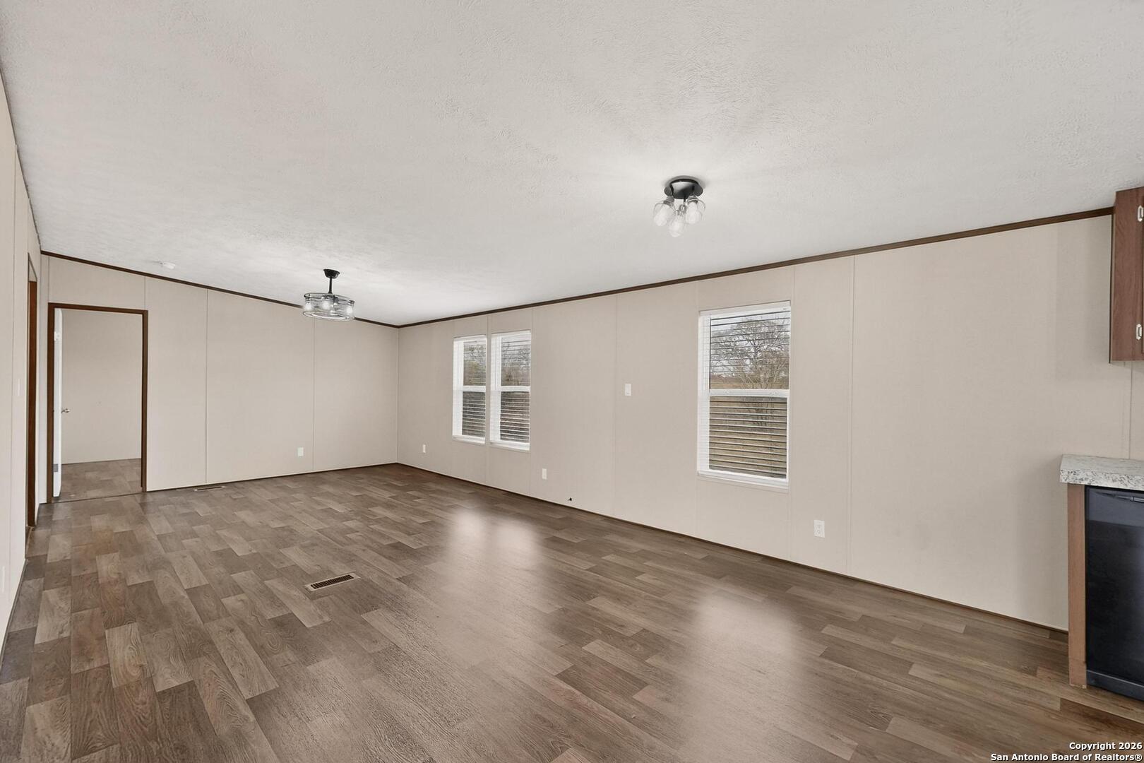19124 La Gloria Road Elmendorf, TX 78112 - Photo 8 of 45 a view of an empty room with wooden floor and a window