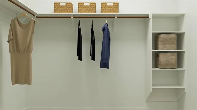 a view of walk in closet with clothes