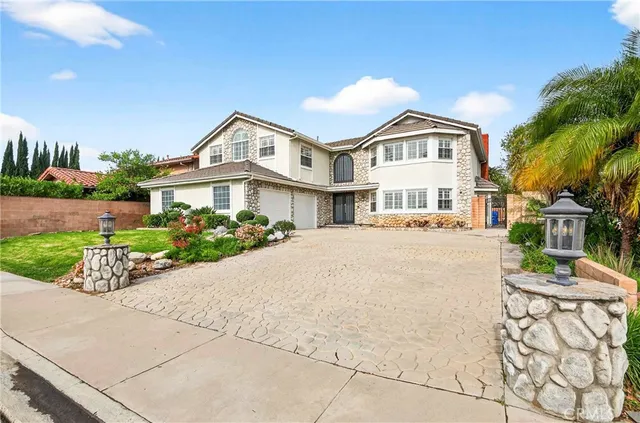 a front view of a residential houses with yard and green space