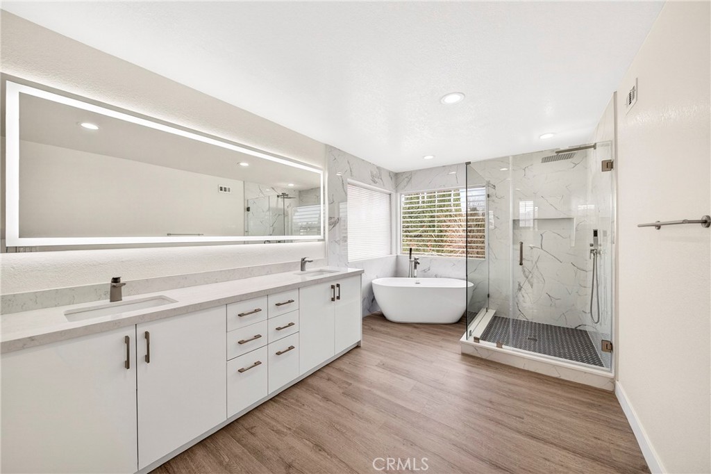 19361 Plummer Street Northridge, CA 91324 - Photo 33 of 42 a spacious bathroom with a double vanity sink a large mirror and shower