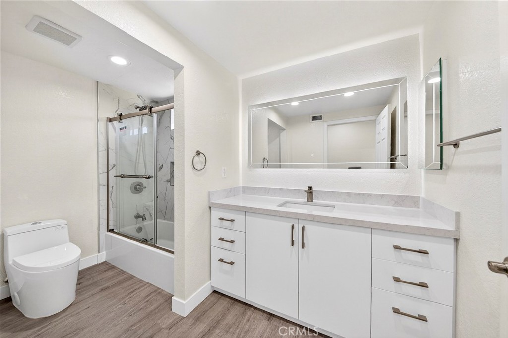 19361 Plummer Street Northridge, CA 91324 - Photo 40 of 42 a bathroom with a granite countertop sink a toilet mirror and shower