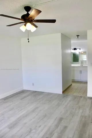 a view of a kitchen with a sink and chandelier fan