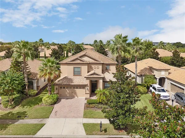 a view of a white house next to a yard with plants and trees