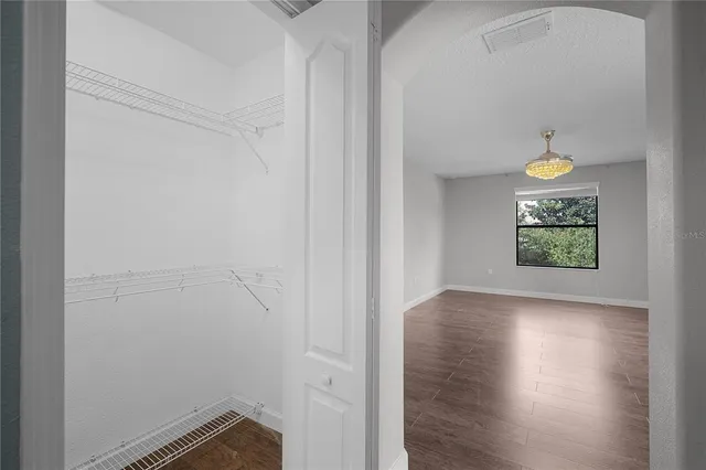 a view of a hallway with wooden floor and a floor to ceiling window