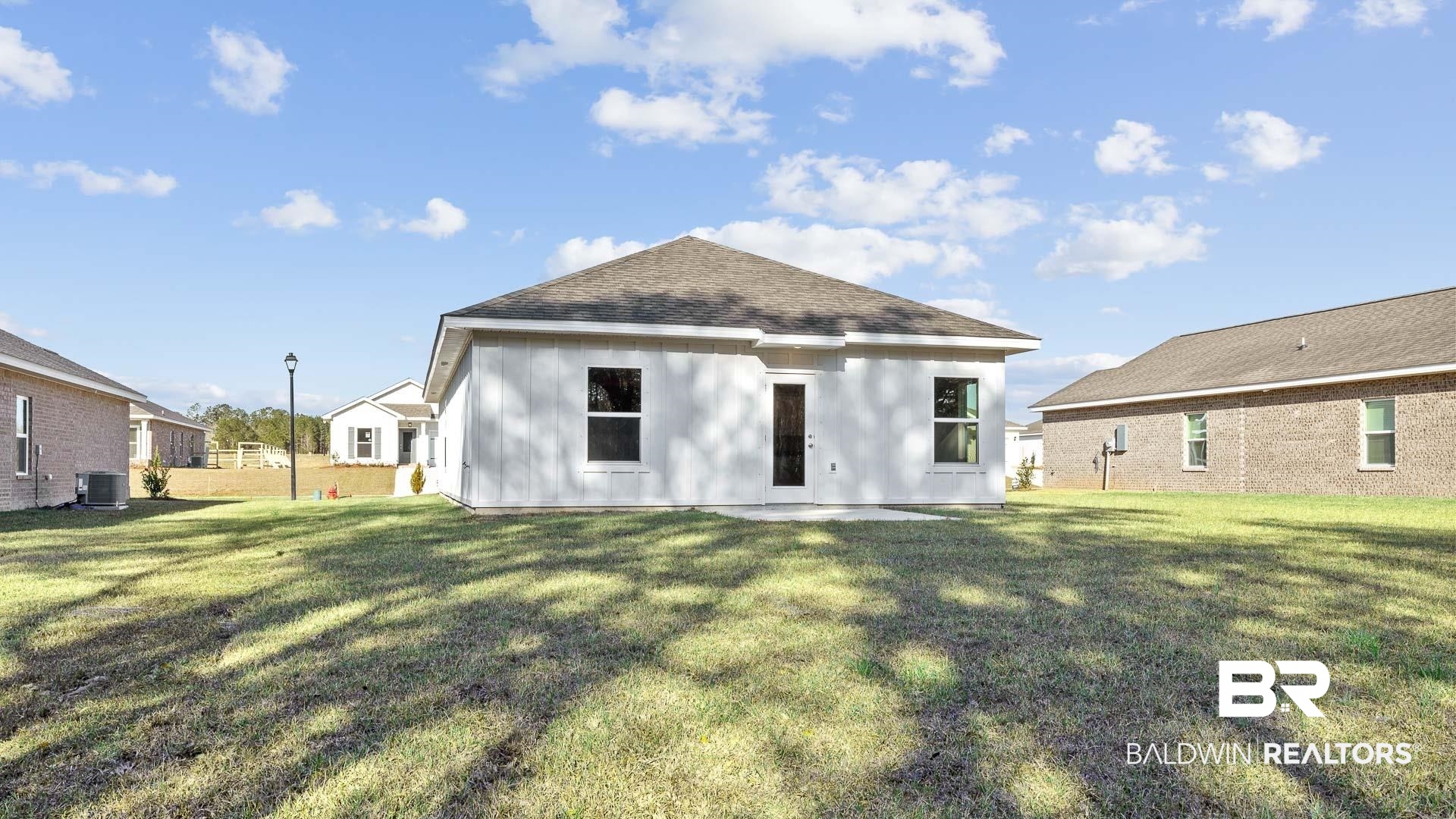 13356 Shea Circle Foley, AL 36535 - Photo 11 of 15 Rear exterior featuring a white facade, gabled roof, and a concrete patio