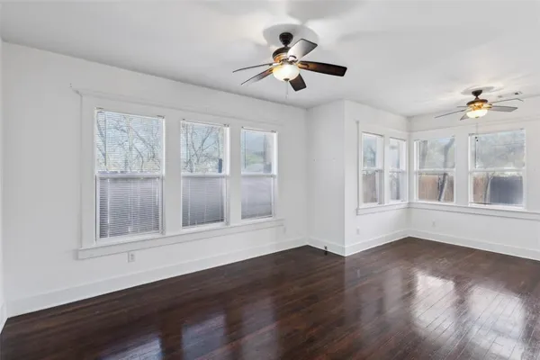 a view of wooden floor and a chandelier fan in a room