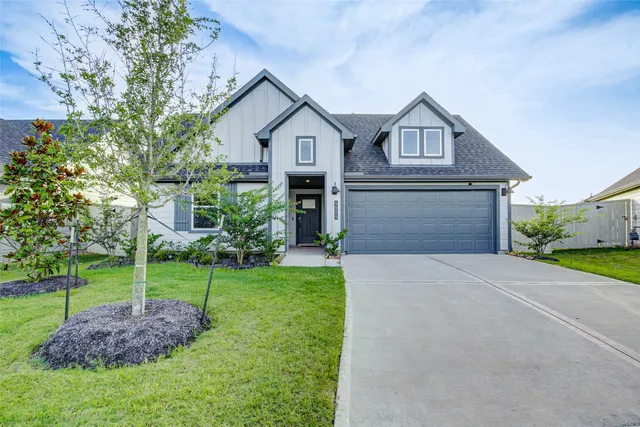 a front view of a house with a yard and trees