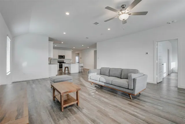a living room with furniture and a wooden floor