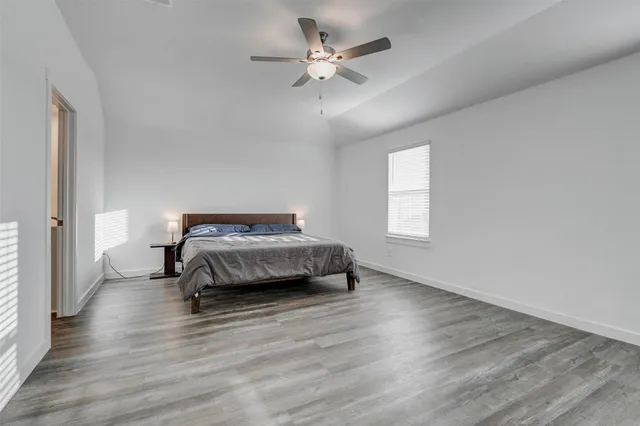 a bedroom with a bed and a ceiling fan