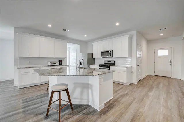 a kitchen with white cabinets and stainless steel appliances