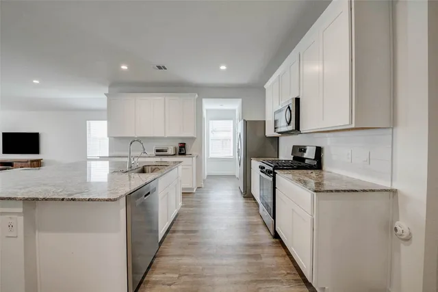 a kitchen with stainless steel appliances granite countertop a sink and a stove