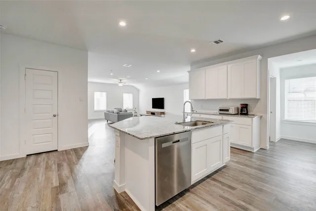 a kitchen with a sink and wooden floor
