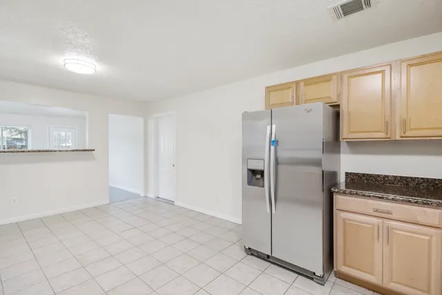 a kitchen with a refrigerator a stove and cabinets