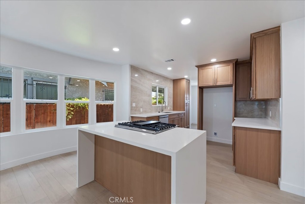 3011 5th Los Angeles, CA 90018 - Photo 18 of 44 a kitchen with stainless steel appliances a stove a refrigerator a sink a dining table and chairs