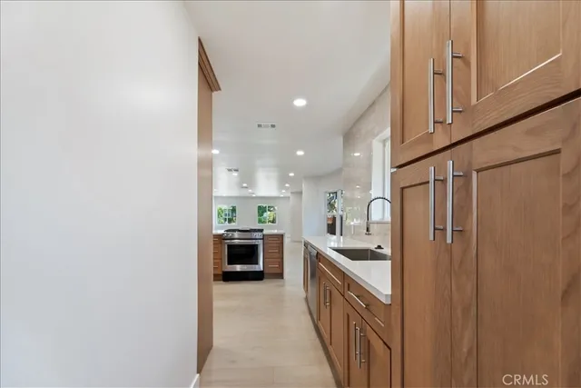 a kitchen with stainless steel appliances granite countertop a refrigerator and a sink