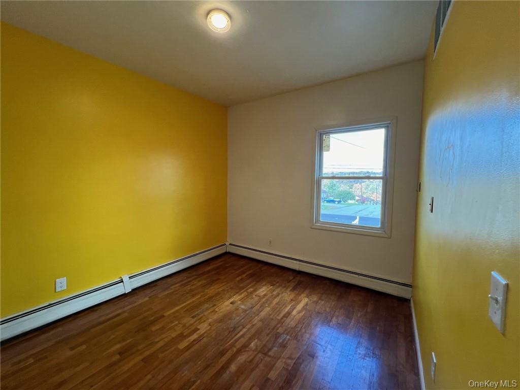 708 Silver Lake-Scotchtown Road Middletown, NY 10941 - Photo 23 of 25 Unfurnished bedroom featuring dark wood-type flooring and a baseboard radiator
