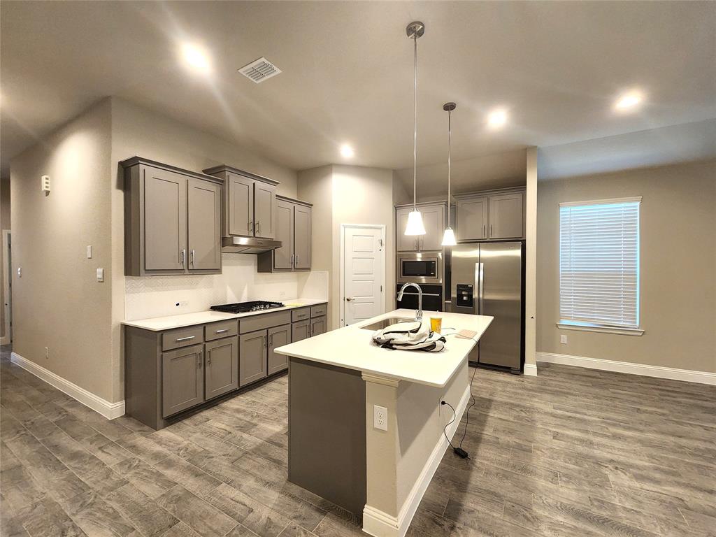 1521 Razorbill Road Denton, TX 76205 - Photo 12 of 31 a kitchen with a sink stove and refrigerator
