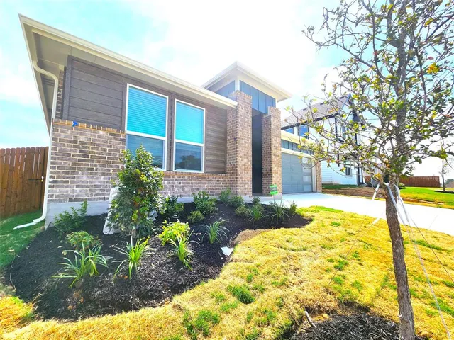 a view of a house with backyard and sitting area