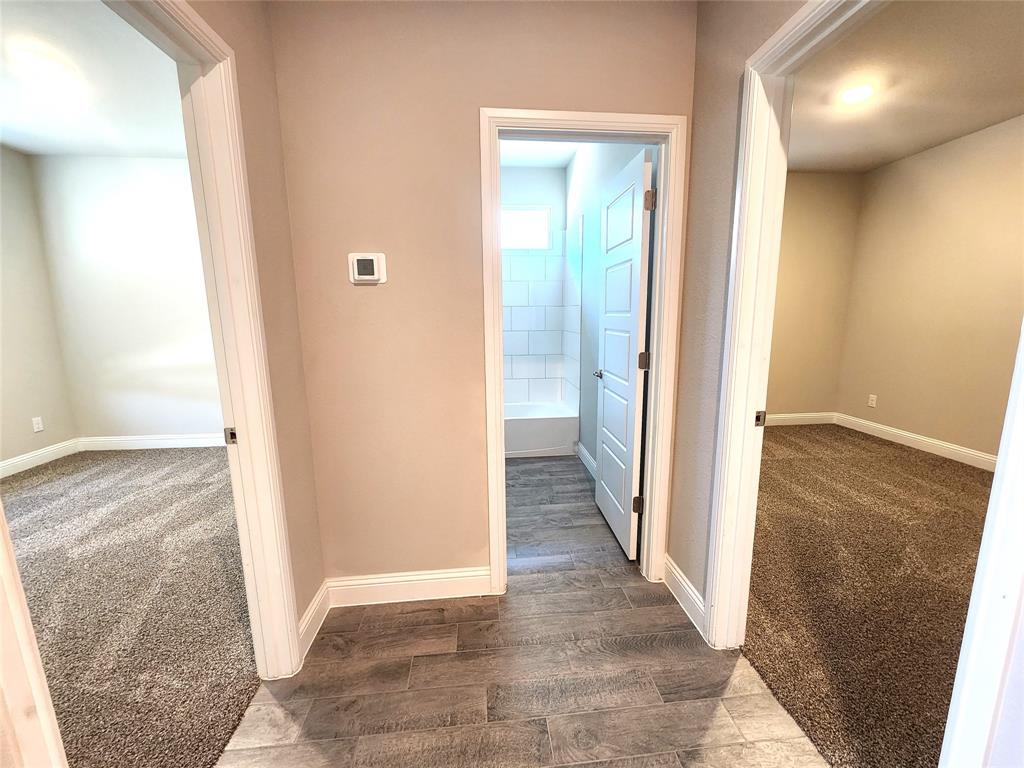 1521 Razorbill Road Denton, TX 76205 - Photo 4 of 31 a view of a hallway with wooden floor and a bathroom