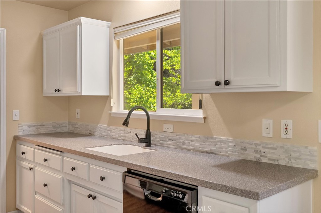 1394 Wagstaff Road Paradise, CA 95969 - Photo 10 of 46 a kitchen with granite countertop a sink white cabinets and a window