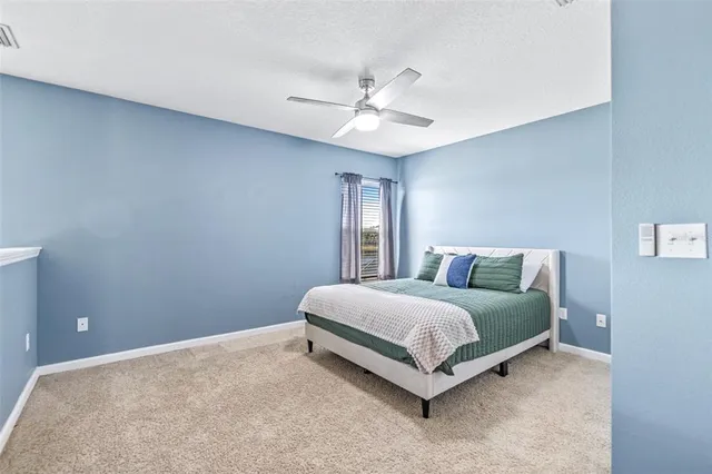 a spacious bedroom with a bed and a ceiling fan