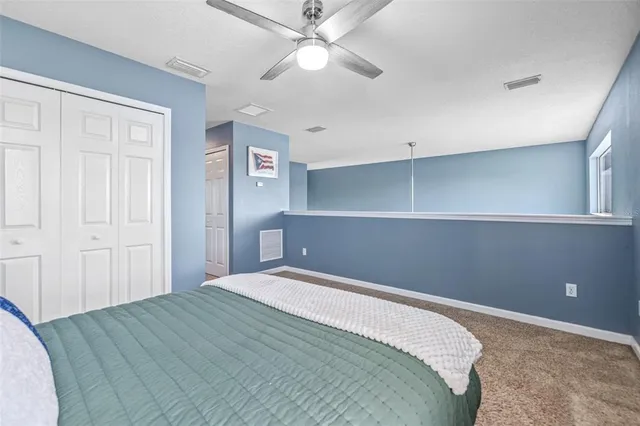 a bedroom with a bed and a ceiling fan