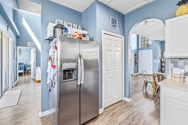 a kitchen with stainless steel appliances granite countertop a refrigerator and a view of living room