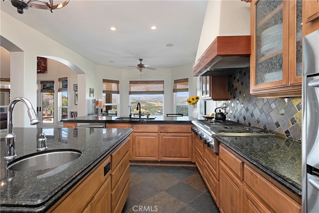 4106 Rock Mountain Road Fallbrook, CA 92028 - Photo 15 of 36 a kitchen with stainless steel appliances granite countertop a sink stove and cabinets