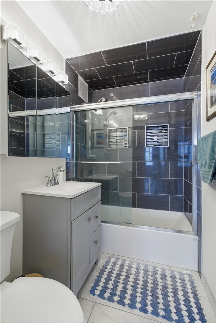 655 West Irving Park Road, Unit 4412 Chicago, IL 60613 - Photo 11 of 19 a bathroom with a bathtub and shower