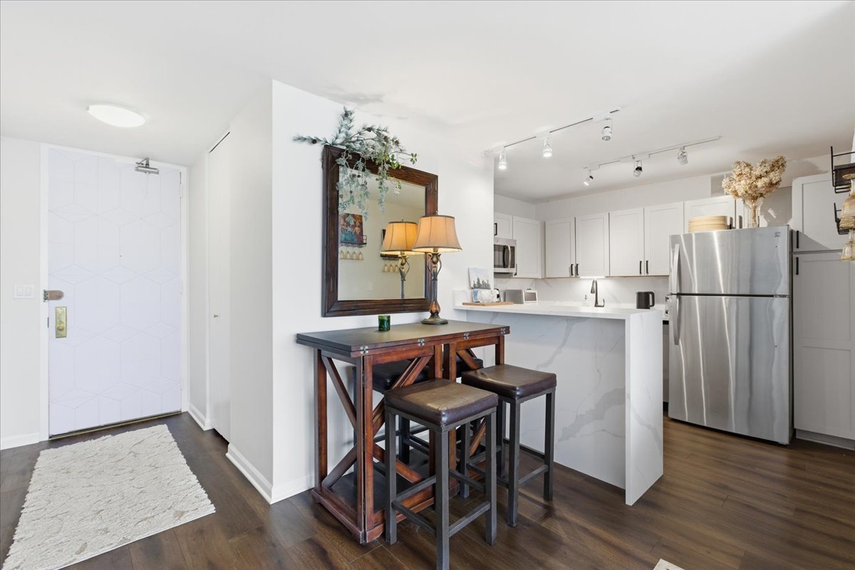 655 West Irving Park Road, Unit 4412 Chicago, IL 60613 - Photo 3 of 19 a kitchen with stainless steel appliances refrigerator wooden table and chairs