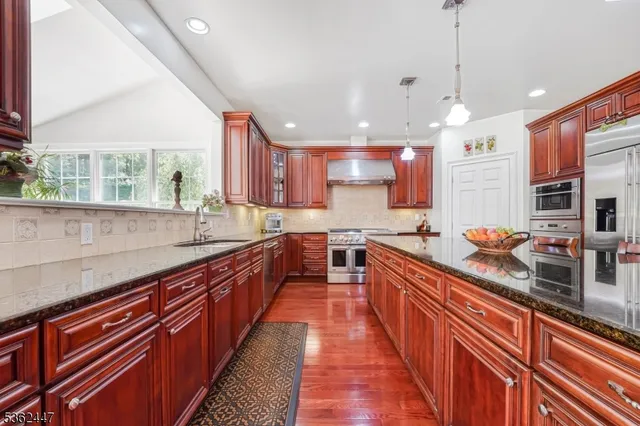 a large kitchen with stainless steel appliances lots of counter space and a sink