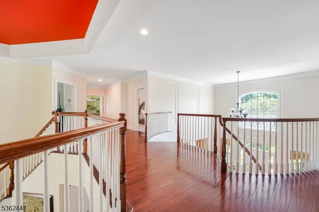 a view of staircase with railing and a chandelier