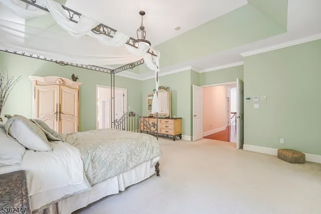 a spacious bedroom with a bed a chandelier and large window