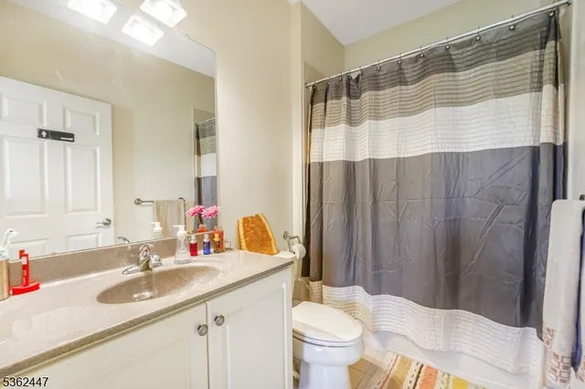 a bathroom with a sink toilet a mirror and shower curtain