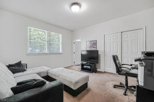 a living room with furniture a window and a flat screen tv