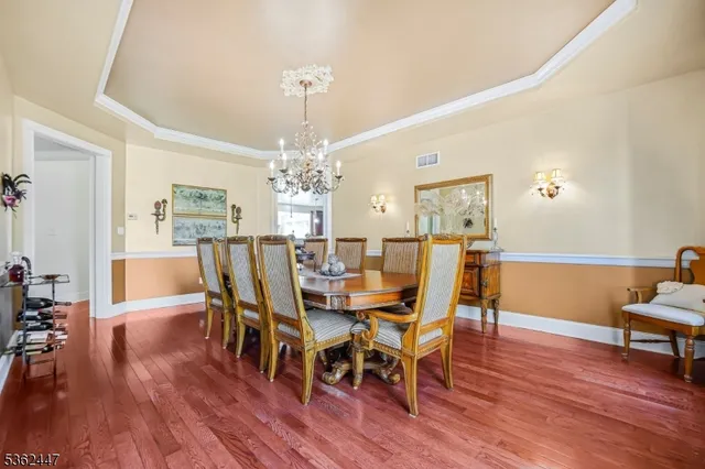 a view of a dining room with furniture a chandelier and wooden floor