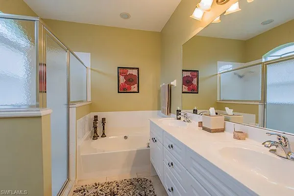 a bathroom with a tub sink and mirror