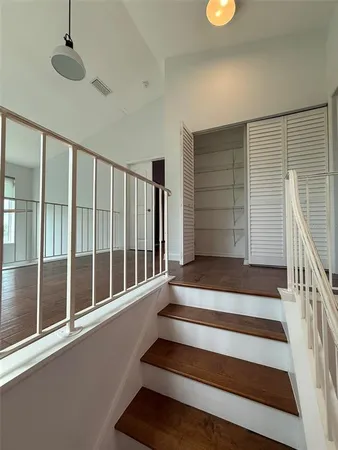 en empty room with wooden floor and fan