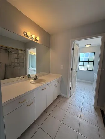 a bathroom with a double vanity sink a toilet and a mirror