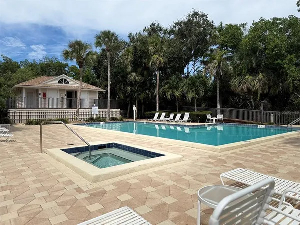 a view of a park with a bench and trees in the background