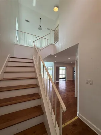 a view of staircase with lots of frames on wall and wooden floor