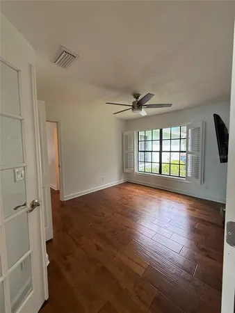 a view of empty room with wooden floor and window