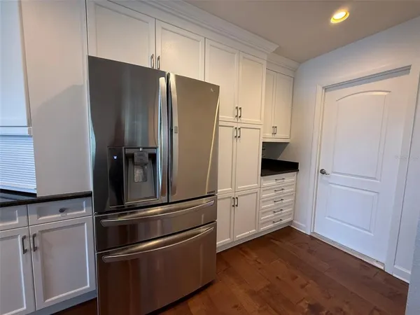 a kitchen with granite countertop a stove top oven and cabinets
