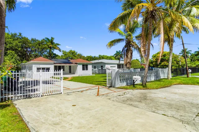 a view of a house with a small yard and flower plants