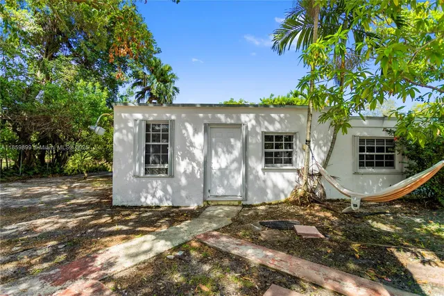 an aerial view of residential houses with outdoor space and trees