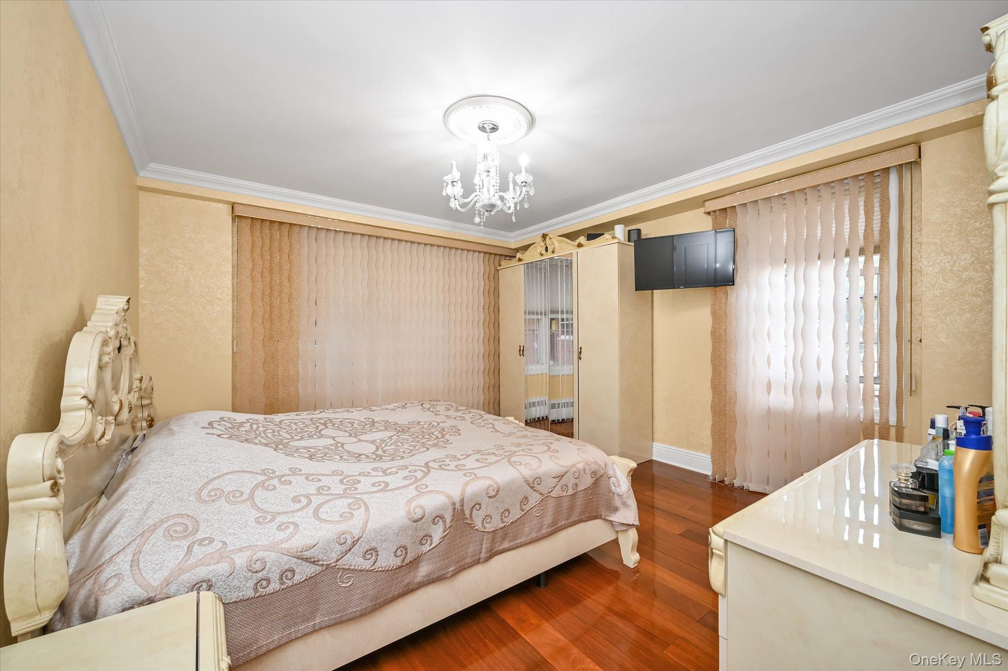 97-37 63rd Road, Unit 2J Queens, NY 11374 - Photo 11 of 19 a bedroom with a bed chandelier and a window