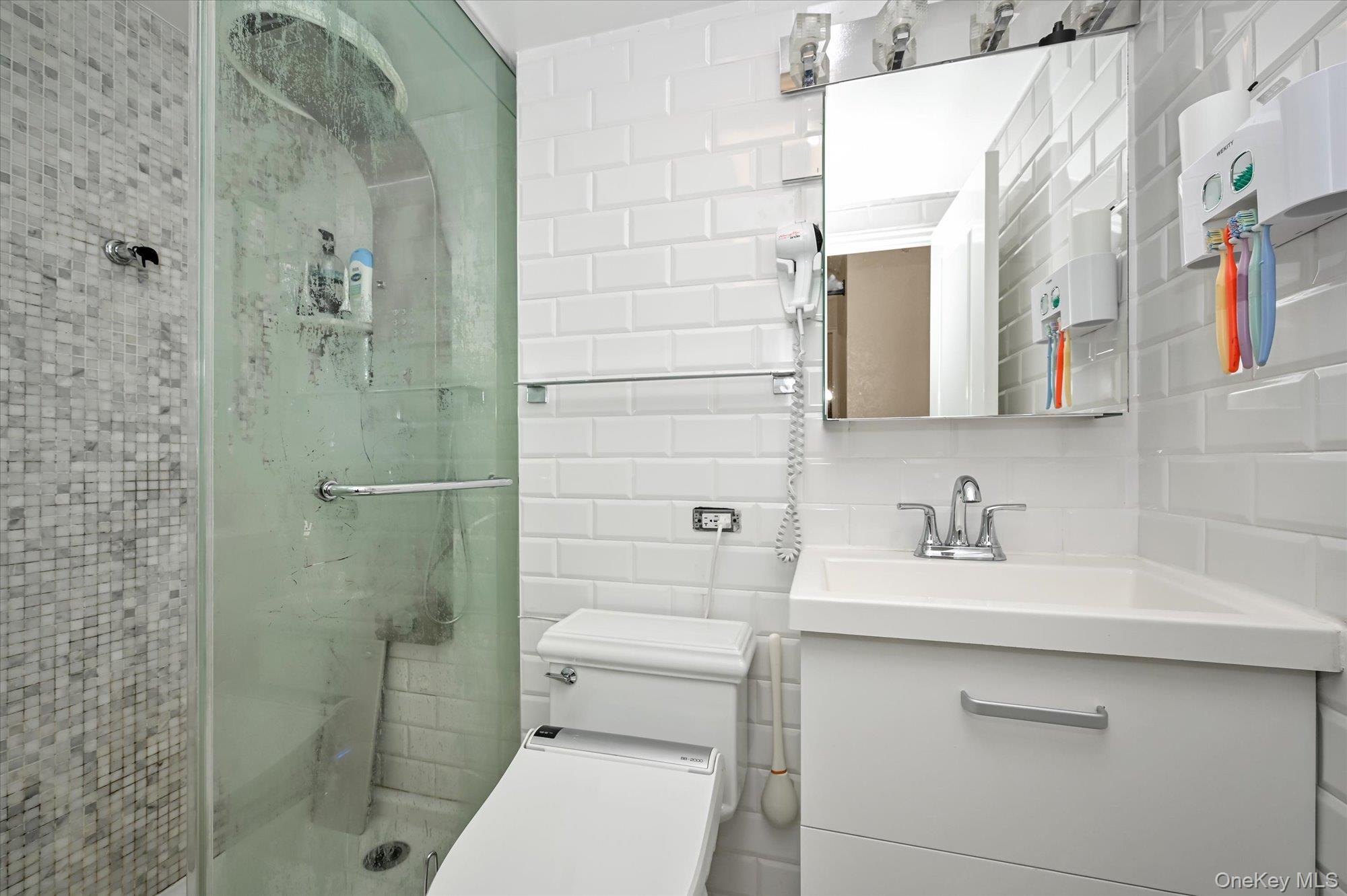 97-37 63rd Road, Unit 2J Queens, NY 11374 - Photo 17 of 19 a bathroom with a sink a toilet and shower